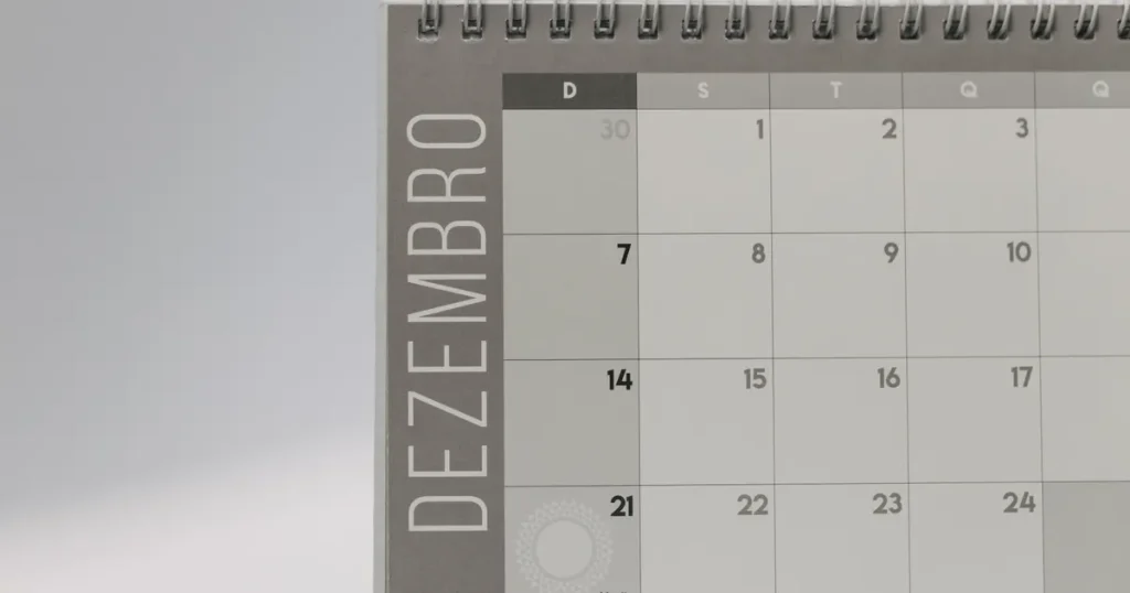 Grey spiral-bound desk calendar month page, illustrating a CAC payback period counted in months