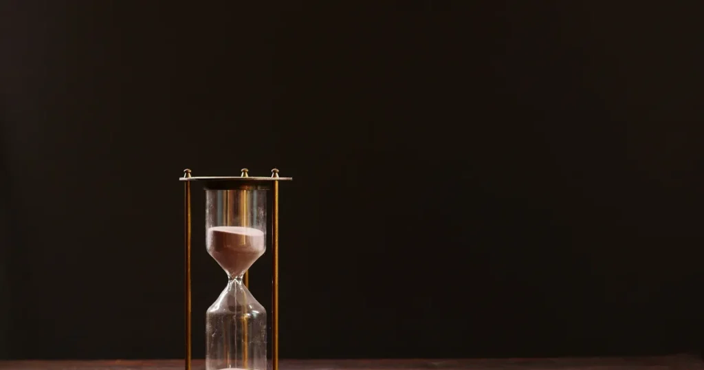 Brass hourglass with sand running down against a dark background, for a guide to Google Ads for SaaS