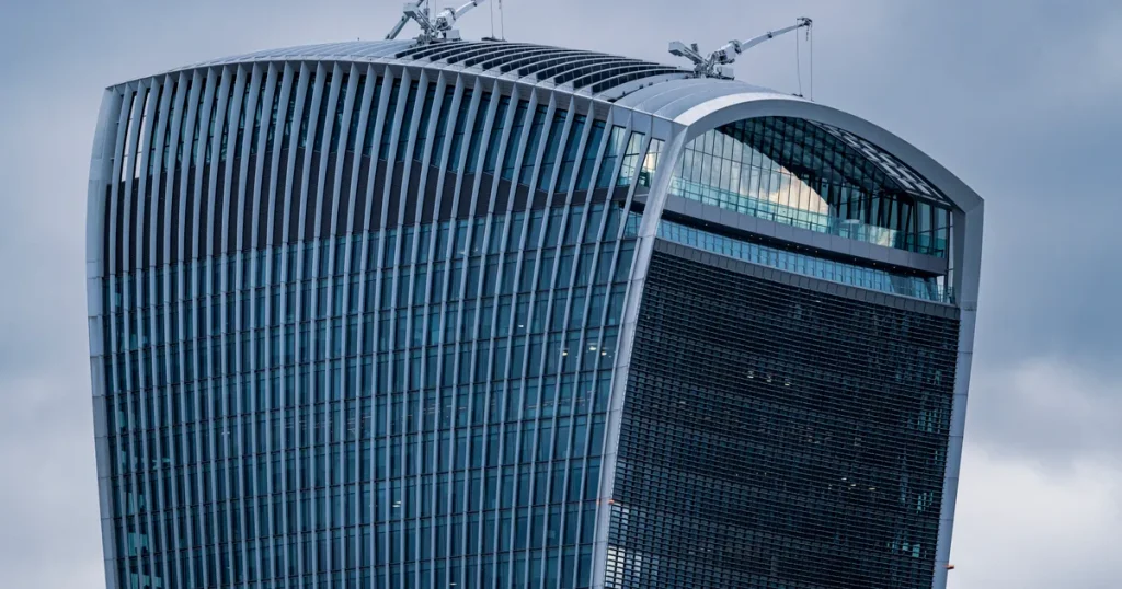 Curved glass facade of the Walkie-Talkie skyscraper in the City of London under grey sky