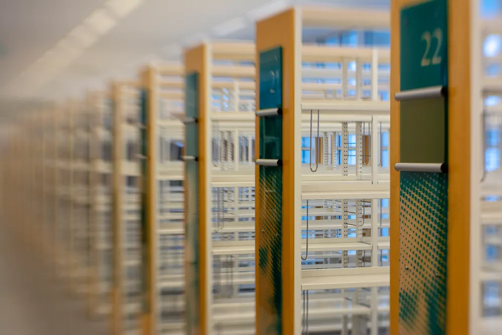 Rows of empty numbered library shelves receding out of focus