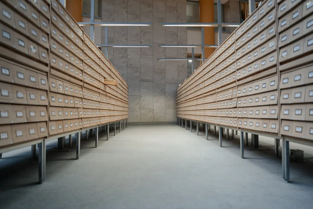 Long archive aisle lined with rows of wooden card-catalogue drawers