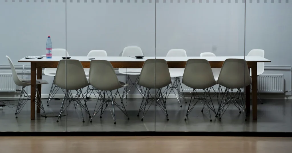 Empty boardroom table with white chairs, the buying committee a B2B SEO strategy has to reach