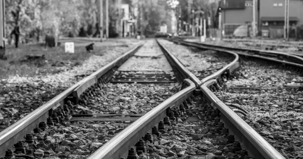 Black-and-white railway track splitting in two at a switch, where MQL vs SQL divide